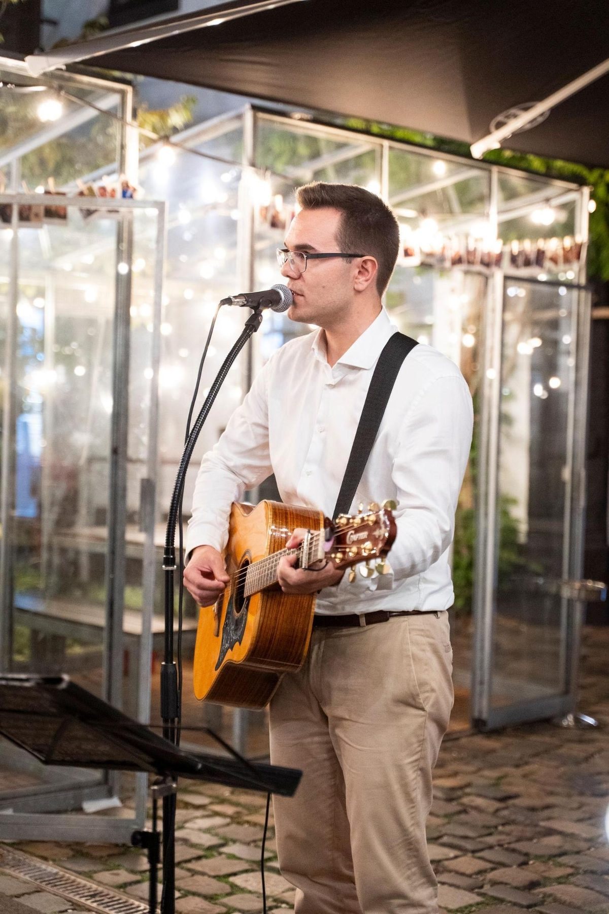 Simon Schütt singt und spielt Akustikgitarre bei einem Auftritt in einer Bar