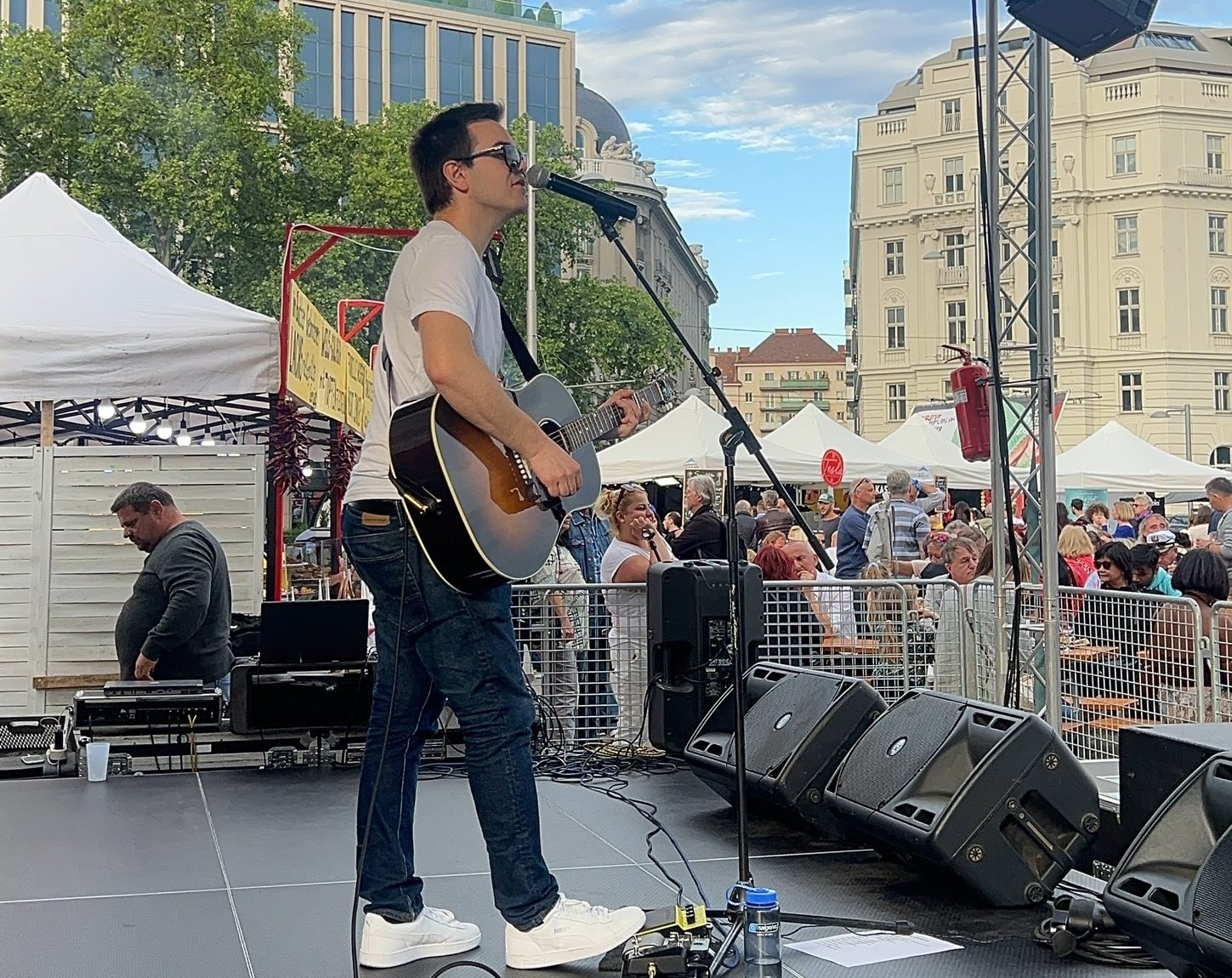 Simon Schütt singt bei einer Feier im Freien unter Lichterketten