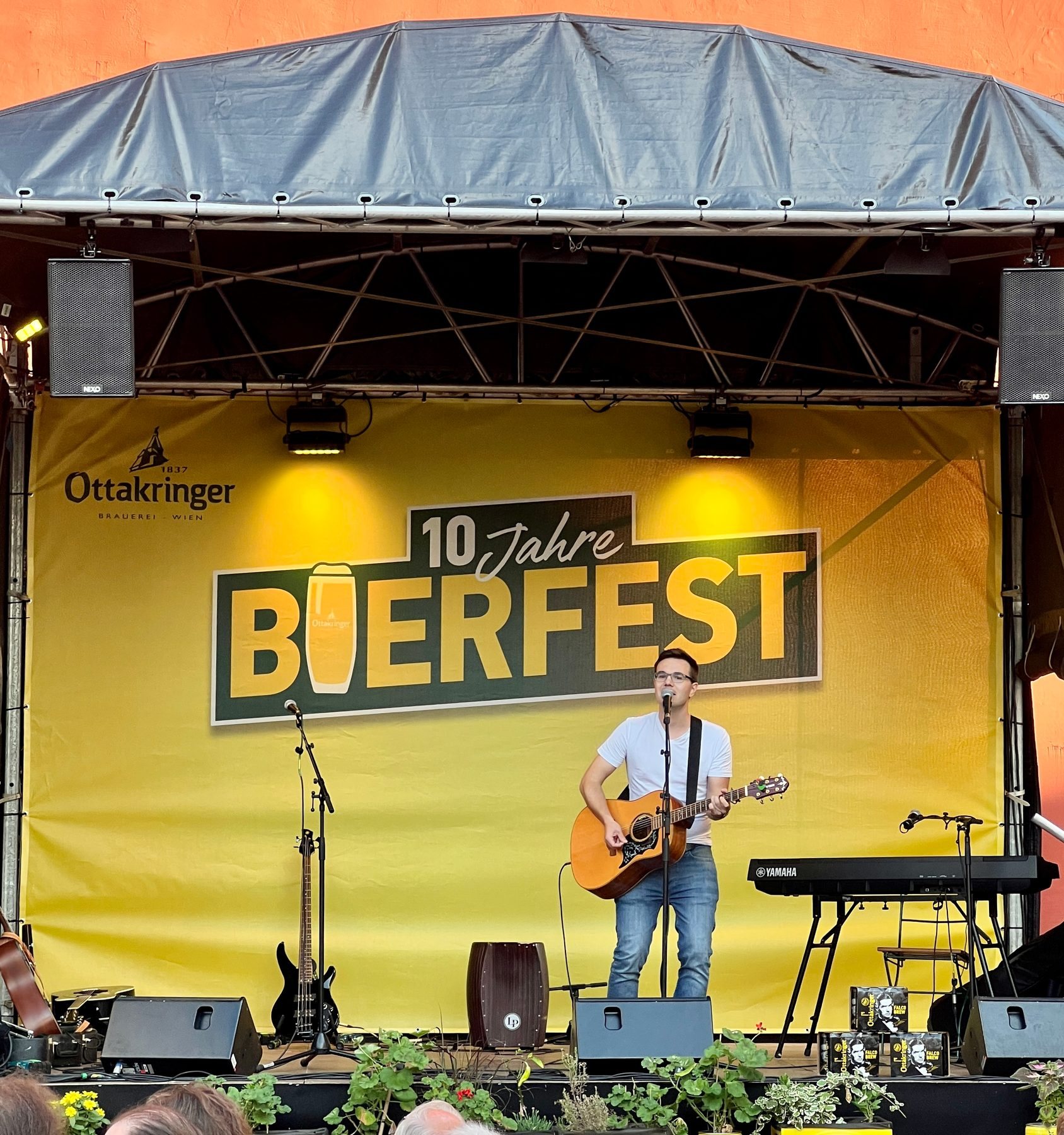 Simon Schütt singt und spielt Gitarre vor Publikum, Schwarzweißaufnahme